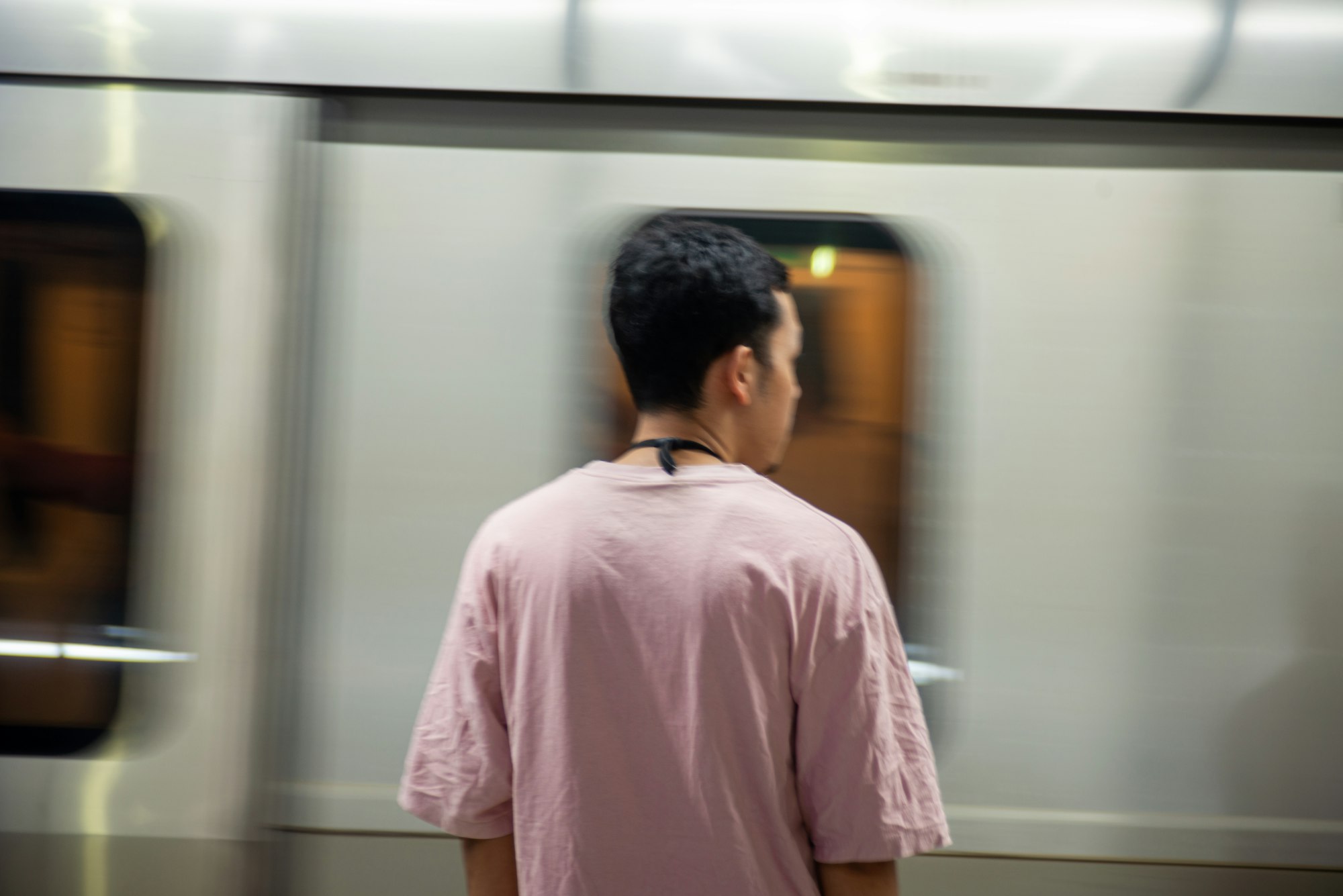 Un voyageur attend devant une rame en mouvement